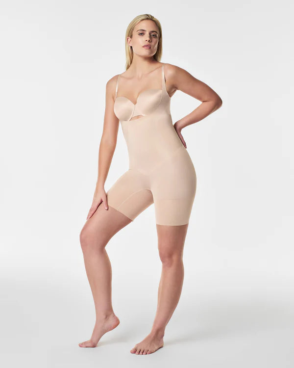 Woman wearing a beige shapewear garment on a white background